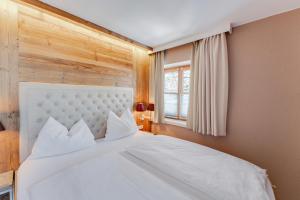 sypialnia z dużym białym łóżkiem i oknem w obiekcie Design Apartment Villa Anna Kitzbühel w mieście Kitzbühel
