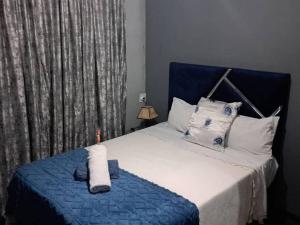 a bedroom with a bed with a blue headboard at The Adventure Begins in Bulawayo