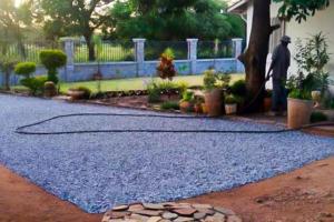 a man standing in front of a yard with a hose at The Adventure Begins in Bulawayo