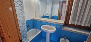 a blue bathroom with a sink and a mirror at Appartement vue Mer sur la Costa Smeralda in Cugnana Verde +19 photos