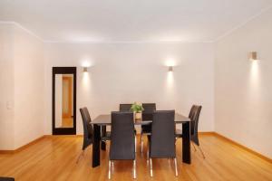 a dining room with a black table and chairs at HolidaysPT - MyOasis I - T2 Apartment in Olhão