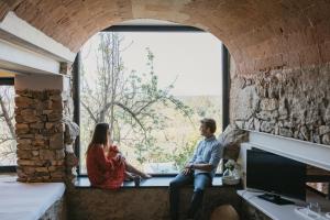 a man and a woman sitting in a window at Flateli Vilopriu in Vilopríu