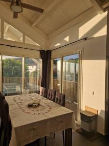 a dining room with a table and a balcony at Villa Entre-Deux Centre in LʼEntre-Deux