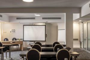a classroom with tables and chairs and a projection screen at Park Beach Hotel in Limassol
