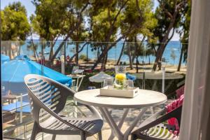 a table and chairs with a drink on a balcony at Park Beach Hotel in Limassol