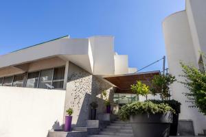 a building with stairs and potted plants in front of it at Park Beach Hotel in Limassol