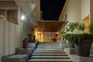 a staircase leading to a building with potted plants at Park Beach Hotel in Limassol