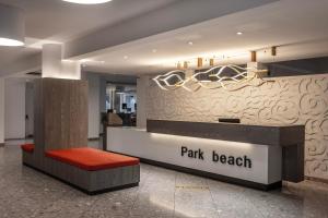 a lobby with a park beak counter with a red bench at Park Beach Hotel in Limassol