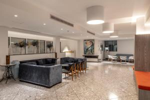 a living room with couches and tables and chairs at Park Beach Hotel in Limassol