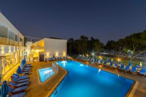 a swimming pool with lounge chairs and a hotel at Park Beach Hotel in Limassol