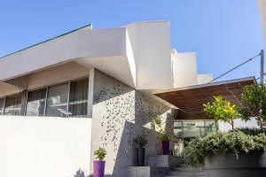 a white building with plants in front of it at Park Beach Hotel in Limassol