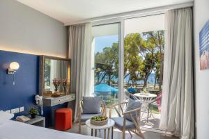 a bedroom with a bed and a room with a balcony at Park Beach Hotel in Limassol