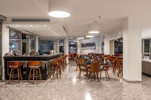 a bar in a restaurant with chairs and tables at Park Beach Hotel in Limassol