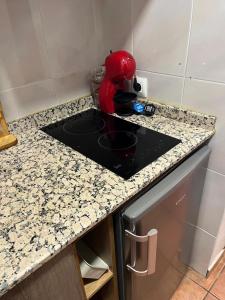 a kitchen counter with a red appliance on it at La Casita Roja Del Arcoíris in Riópar
