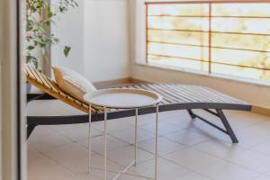 a chair and a table in a room with a window at The Green - Svolio Hospitality in Komotini