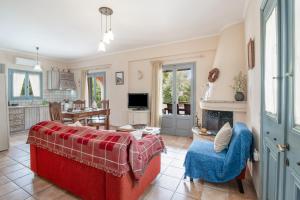 a living room with a red couch and a fireplace at Villa Simeoni Lefkada in Lefkada Town
