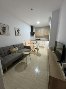 a living room with a couch and a table at Apartamentos Modern Homes in Chiclana de la Frontera