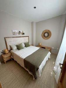 a bedroom with a large bed and a mirror at Apartamentos Modern Homes in Chiclana de la Frontera