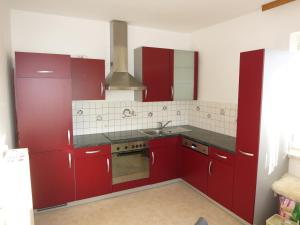 eine Küche mit roten Schränken und einem Waschbecken in der Unterkunft Appartement Marija in Knittelfeld
