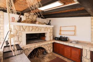 a kitchen with a stone fireplace and a sink at House Anna in Drage