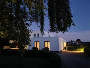 une maison blanche éclairée la nuit dans l'établissement Eilers, Katja Lilly, Ferienwohnung Lilly, à Varel