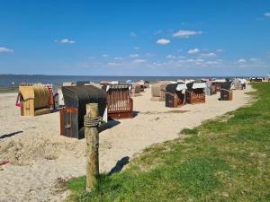une rangée de cabanes de plage sur la plage dans l'établissement Eilers, Katja Lilly, Ferienwohnung Lilly, à Varel