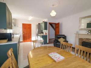 a kitchen and living room with a wooden table and a kitchen and a dining room at Teach Annie Agus Paddy in Gortahork