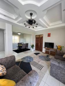 モンバサにあるShanzu Creek Two Bedroom Ocean Viewのソファと薄型テレビのあるリビングルーム