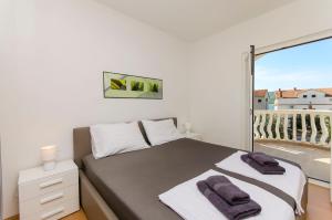 a bedroom with a bed and a large window at Apartments Rosanda in Pirovac