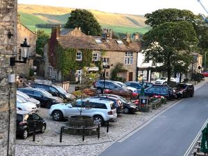 a group of cars parked in a small town at Square View Grassington in Grassington