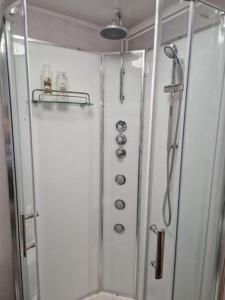 une douche dans une salle de bain avec une porte vitrée dans l'établissement Chester Le Street's Emerald 3 Bed House, à Chester-le-Street