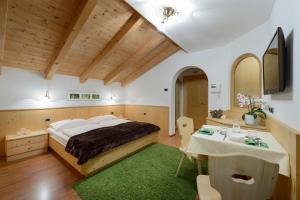 sypialnia z dużym łóżkiem i stołem w obiekcie Residence Sovara w mieście Santa Cristina Valgardena