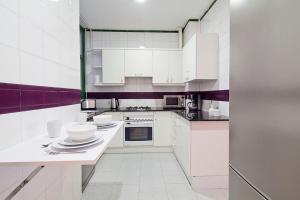 Friendly Rentals Caliu في برشلونة: مطبخ أبيض مع خزائن بيضاء وأجهزة