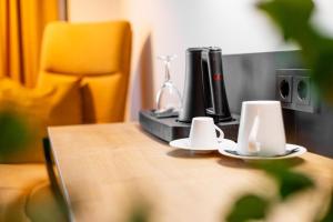 a wooden table with two coffee cups on top of it at Frida Hotel & Café in Bassum