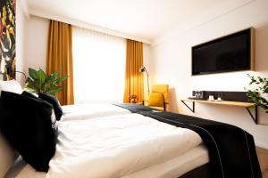 a hotel room with a bed and a television at Frida Hotel & Café in Bassum