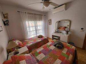 une chambre avec deux lits et un miroir dans l'établissement Casa Mariposa Guesthouse, à Playa de San Juan