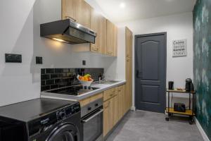 a kitchen with a stove top oven next to a washer at Le Louvre Lens - Premium - Wifi - Balcon & Parking in Lens