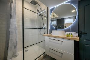 a bathroom with a shower and a sink and a mirror at Le Louvre Lens - Premium - Wifi - Balcon & Parking in Lens