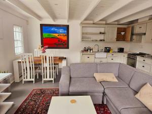 ein Wohnzimmer mit Couch und Tisch und eine Küche in der Unterkunft PinotageLuxuryCollection 9A Herte Suite in Stellenbosch