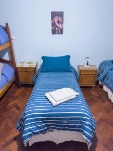 a bed with blue and white sheets and two night stands at El Oasis in Mendoza +27 photos