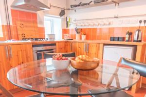 New MillsPass the Keys Pet & Cycle Friendly Garden Home in New Mills的厨房配有玻璃桌,上面放着一碗水果