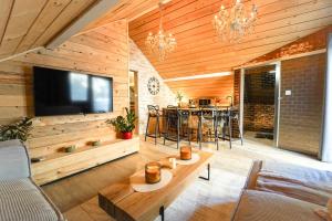 un soggiorno con televisione, tavolo e sedie di Studio de luxe a Theux