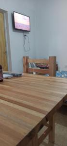 Una mesa de madera con un televisor en la pared. en Tu lugar de descanso III, en Federación