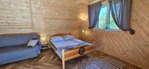 a small bedroom with a bed and a window at ECO Apartament z dużym ogrodem in Murzasichle