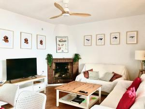 a living room with a couch and a tv at La Paloma, Chalet a pie de playa in Águilas
