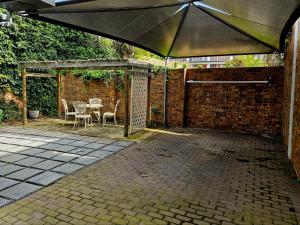 eine Terrasse mit Sonnenschirm und Tisch und Stühlen in der Unterkunft PinotageLuxuryCollection 9A Herte Suite in Stellenbosch