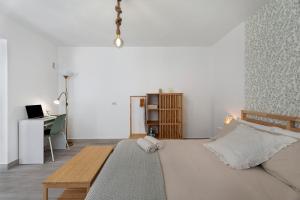 a white bedroom with a bed and a desk at El Rinconcito De Niña in Tijoco de Abajo