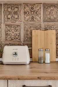 a toaster and two glasses on a wooden table at ARI Central Grand Apartments - Luxurious Stay in Arad