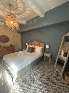 a bedroom with a bed and a mirror and a chandelier at La maison n1 Arles terrasse in Arles