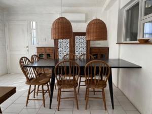 a dining room with a black table and chairs at Casa Drummond in Ciudad Lujan de Cuyo